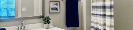 a bathroom with a toilet and a sink and a mirror at Mainstreet Apartments, Clearwater